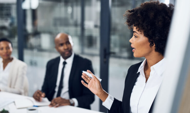 Shot of a young businesswoman delivering a presentation to her colleagues in the boardroom of a modern office